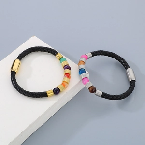 Dettaglio di bracciali in pelle intrecciata con perline colorate e chiusure magnetiche