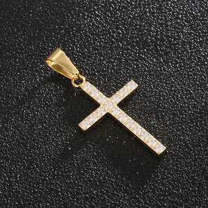Gros plan d'un pendentif croix en titane doré serti de zircons cubiques transparents