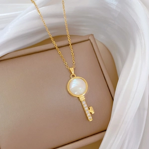 Elegant gold titanium necklace with a cat-eye key pendant and sparkling clear zircons