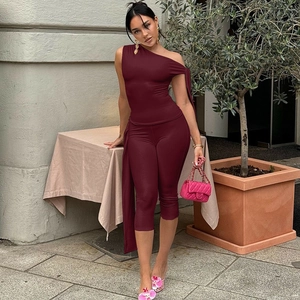 Detail of burgundy one-shoulder top and shorts set featuring side drape waist tie design