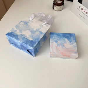 Blue and pink gradient starry sky gift box and matching paper bag with white ribbon