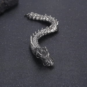Close-up of retro silver dragon bracelet with green eyes and detailed punk scales