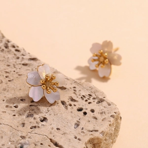 Detailed macro of cherry blossom stud earrings with 18K gold plating and natural pearl shell