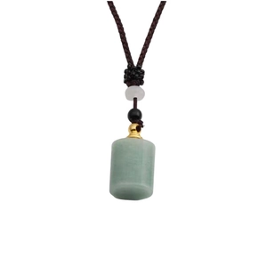Detail of green jade perfume bottle pendant with golden hardware on brown woven cord