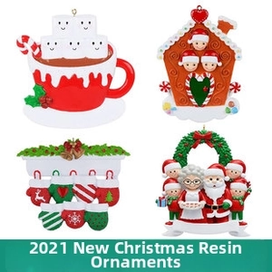 Detail view of four festive resin Christmas ornaments including cocoa and gingerbread house