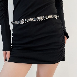 Detail of vintage bohemian waist chain with silver sun pattern discs on black leather strap