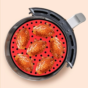 Dettaglio del tappetino in silicone rosso per friggitrice ad aria con ali di pollo