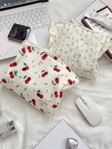 Trousse de toilette matelassée à motifs floraux et cerises sur un bureau d'accueil