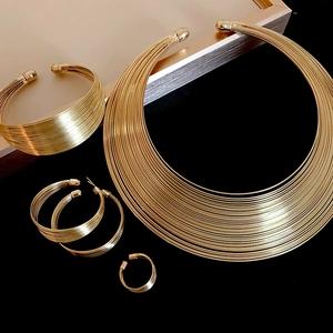 Close-up of golden multi-layer metal wire jewelry set featuring necklace and bracelet