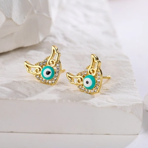 Detailed view of heart-shaped gold stud earrings with devil eye enamel and crystals