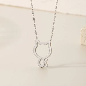 Detail of silver hollow cat outline pendant on a delicate stainless steel necklace