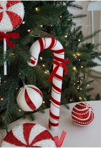 Detail of red and white velvet candy cane and lollipop ornaments on a Christmas tree