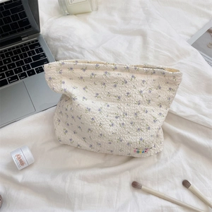 Detail of floral seersucker toiletry bag with zipper and logo in a lifestyle setting