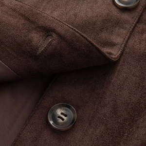 Macro detail of dark brown suede leather jacket showing texture and buttons