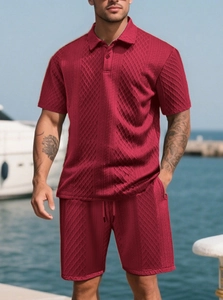 Detail of red waffle knit texture on men's polo and drawstring shorts set at the beach