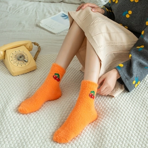 Cosy bright orange coral fleece socks with cherry embroidery in a vintage home setting