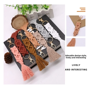 Detail showing various colors of handmade macrame tassel keychains with golden metal clips