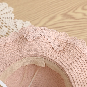 Dettaglio macro della trama di paglia rosa con pizzo e fascia antisudore interna