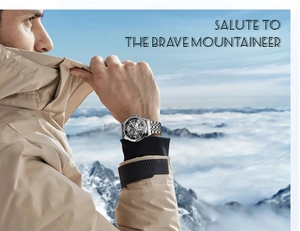 Men's skeleton mechanical watch with silver steel strap on a mountaineer's wrist