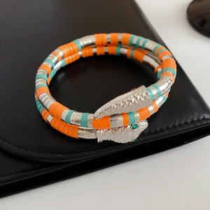 Close-up of silver snake head clasp with green crystal eyes on a beaded wrap bracelet