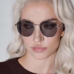 Classic silver metal round frame sunglasses with dark grey lenses on a female model