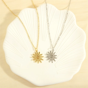 Detail of gold and silver sun necklaces with spiral pattern on decorative shell plate