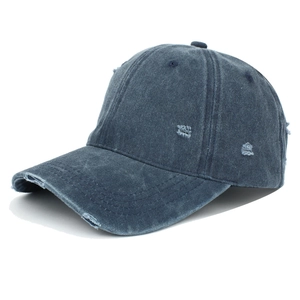 Close-up of distressed denim baseball cap with vintage washed texture and ripped details