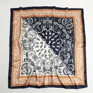 Macro view of blue and orange paisley silk scarf with detailed vintage pattern edges