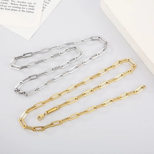 Detail of silver and gold paperclip chain necklaces with lobster clasps on white background