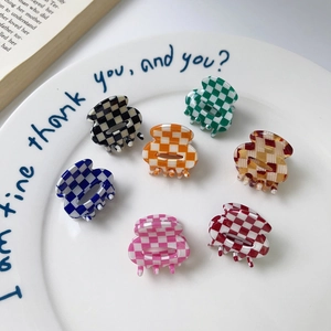 Set of 7 mini acetate hair clips featuring colorful checkered patterns on a ceramic plate