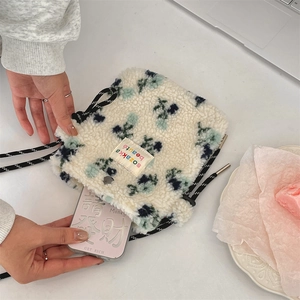 Detail of floral plush crossbody bag showing inner storage capacity for a smartphone
