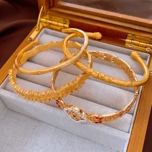 Vintage style hollow gold bangles with pearls and gemstones in a premium jewelry box