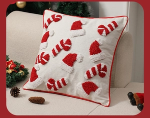 Detailansicht des Weihnachtskissens mit Tufting-Stickerei und roter Paspel auf dem Sofa