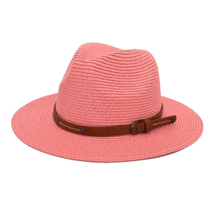 Detail view of pink straw sun hat showing brown leather belt and metallic buckle