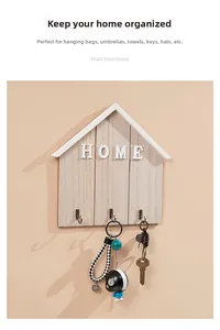 Macro detail of wooden house-shaped key rack with bronze hooks and 3D HOME letter design