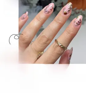 Short almond press-on nails with autumn pumpkin and gold leaf patterns over pink base