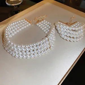 Elegant four-layer pearl necklace and bracelet set with golden metal clasp