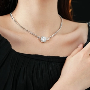 Gros plan d'un collier chaîne gourmette en argent avec pendentif zircon carré sur un mannequin