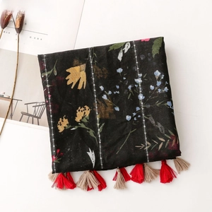 Detail of vintage floral scarf with shiny silver thread and colorful tassel trim decor