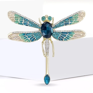 Exquisite golden dragonfly brooch with blue rhinestones and teal enamel wings on white stand