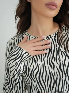 Close-up of elegant zebra print pajama top with minimalist round neckline and smooth fabric
