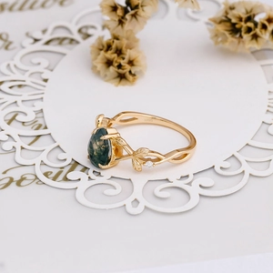Macro shot of 925 silver vine ring with teardrop moss agate and sparkling zircon