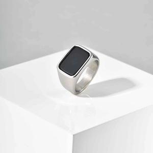 Macro shot of silver stainless steel signet ring with a rectangular black stone inlay