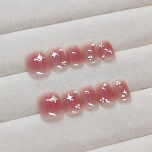 Pink blush gradient press-on nails with white stars and rhinestones in short square shape