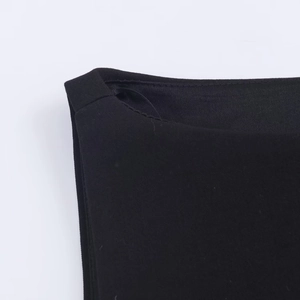 Close-up of neckline stitching and textured black fabric on women jewelry button top