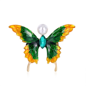 Macro detail of enamel butterfly brooch with yellow-green wings and pearl accent