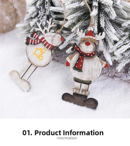 Detail of wooden reindeer ornament with red hat on a snow-covered pine branch