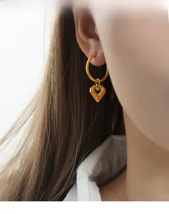 Detailed view of 18k gold plated stainless steel hoop earring with hollow heart pendant