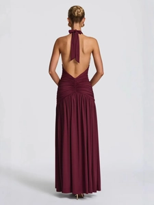Elegant deep red backless halter maxi dress with ruched waist detail and draped skirt