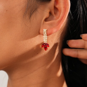 Gros plan de boucles d'oreilles pendantes avec pierres marquises rouges et zircons blancs